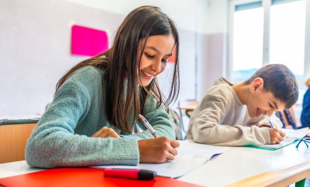 alunos escrevendo redação na sala de aula.