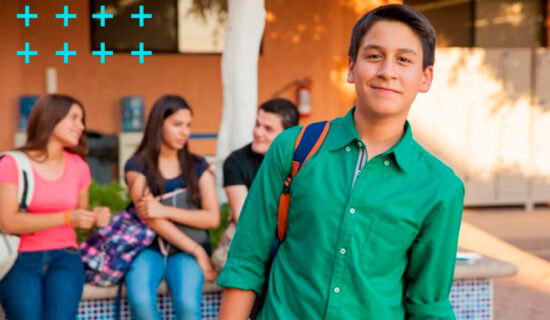 jovem estudante de pé e seus amigos conversando na porta da escola.