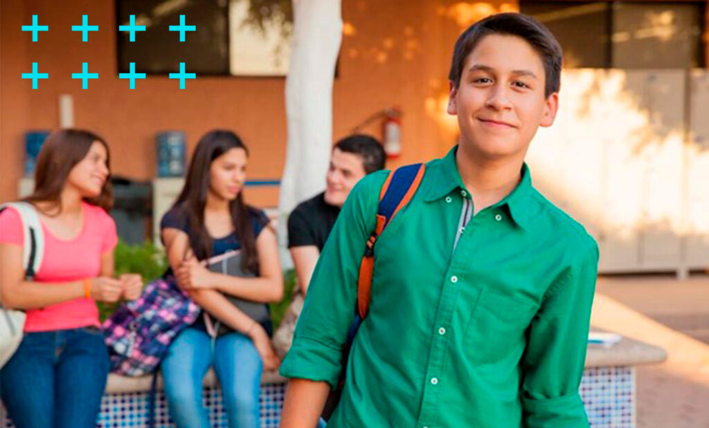 jovem estudante de pé e seus amigos conversando na porta da escola.