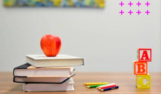Pilha de livros com maça e cubos com as letras a, b e c.