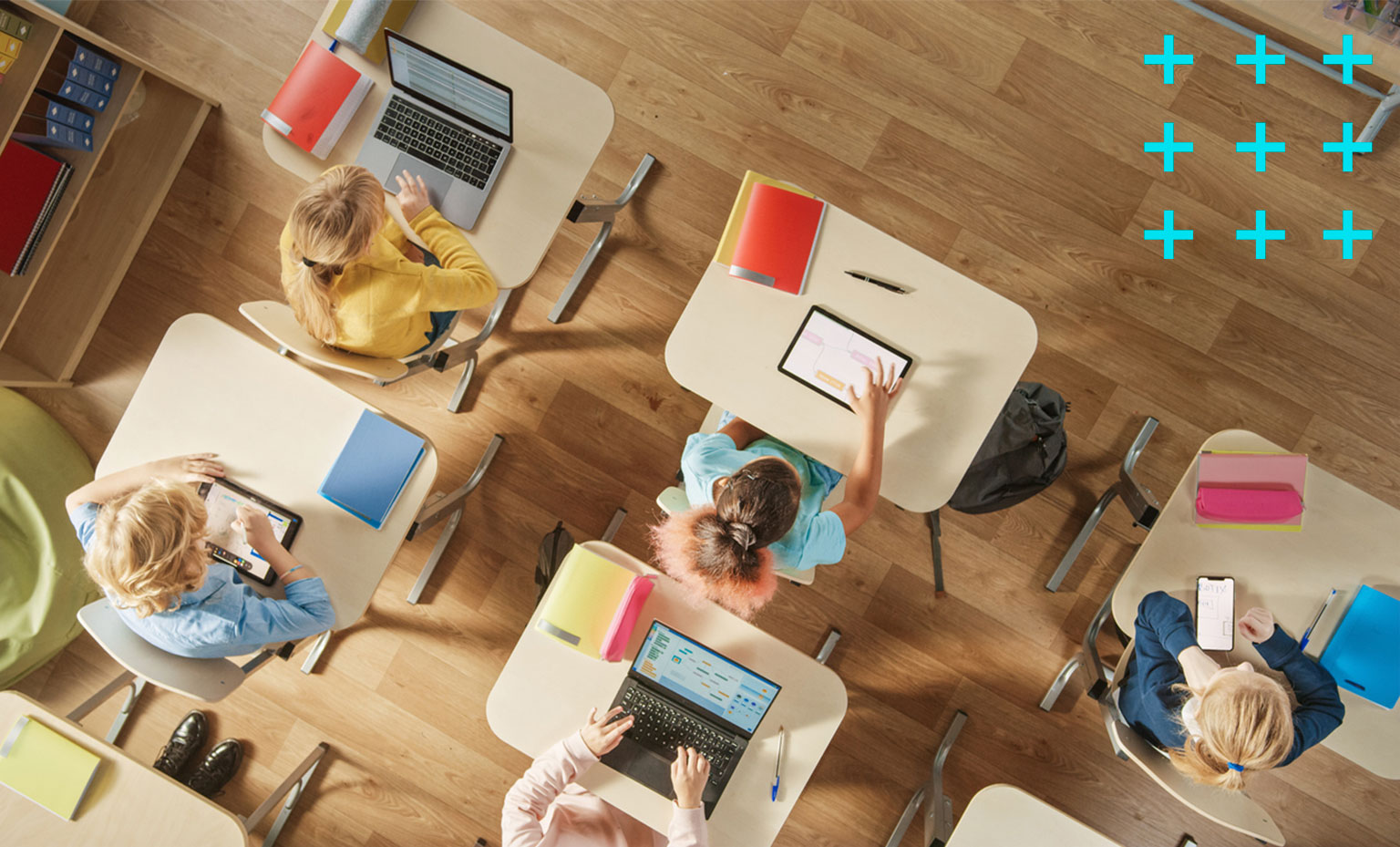 Visão de cima da sala de aula com as mesas e alunos.