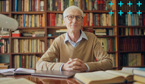 Homem idoso sentado em uma biblioteca.