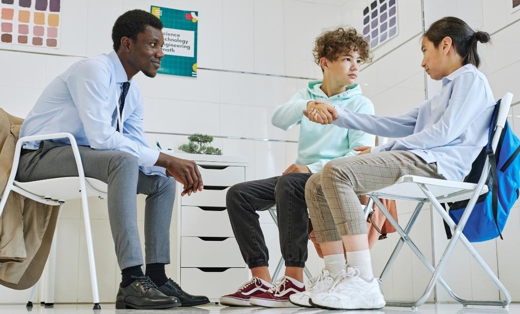mediador orientando dois alunos durante um processo de reconciliação