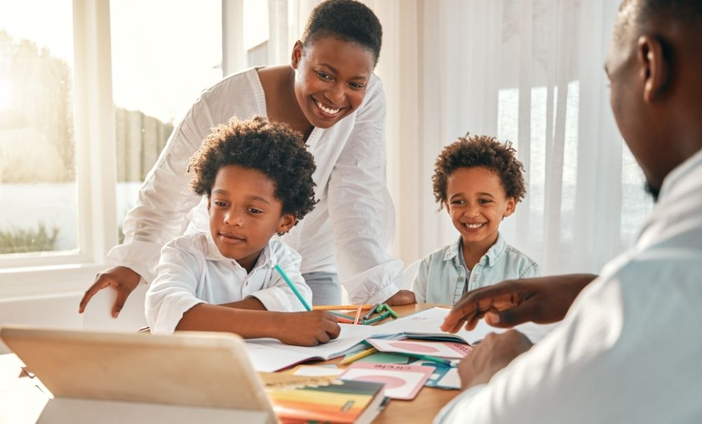pais acompanhando os filhos em atividades escolares em casa.